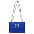 Royal blue quilted crossbody bag featuring a golden bow buckle and chain strap - Blue