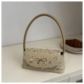 Stroh-Handtasche mit Blumenstickerei, goldenem Bogen-Verschluss und Ledergriff auf Tisch - Khaki