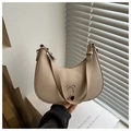 Detail of beige crescent underarm bag with silver bow accent and thick shoulder strap - Khaki
