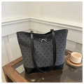 Detalle del bolso tote gris con estampado de corazones, asas de cuero y lazo plateado - Corazón