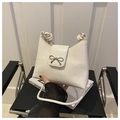 Detalle del bolso tipo cubo blanco con broche de lazo plateado y correa con nudo artesanal - Blanco