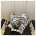 Close-up of metallic silver crescent bag featuring a large bow and ruffled strap detail - Silver