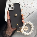 Detail of matte black iPhone case with gold rose and luxury pearl bracelet strap - Small Camellia Rhinestone Pearl Chain / Black / iPhone 7/8/SE 2020