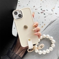 Detail of cream silicone iPhone case with gold rose relief and pearl wristlet strap - Small Camellia Rhinestone Pearl Chain / Apricot / iPhone 7/8/SE 2020