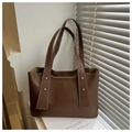 Detail view of brown PU leather tote bag with rivets and white stitching on wide strap - Coffee