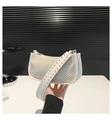 Detail van witte geweven baguette tas met zilveren metalen ogen op de brede PU-band - Wit