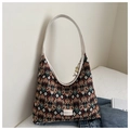 Detail of multi-color geometric diamond pattern fabric and white fashion label on tote bag - Coffee