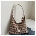 Detail of colorful geometric pattern tote bag with leather strap and fashion label - Khaki