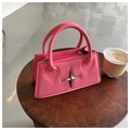 Modische kleine Handtasche in leuchtendem Pink mit silbernem Stern auf Holzoberfläche - Rosarot
