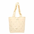 Bolso tote beige con volantes, detalles de cordón y remaches metálicos en fondo blanco - Amarillo