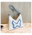 Detailansicht der weißen Ledertasche mit blauem Schmetterling und silberner Metallkette - Weiß