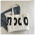 Vista piatta della grande borsa tote bianca con stampa noco e giacca di jeans - Stile con Grande Stampa di Lettere (noco) / Bianco