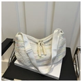 Primer plano de bolso tote acolchado con bordados coloridos y textura de monograma - Blanco