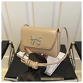 Detalle de bolso baguette beige con lazo plateado metálico y correa fina ajustable - Caqui