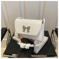 Detalle de bolso bandolera de cuero blanco con hebilla de lazo plateada y correa con nudos - Blanco