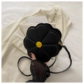 Detail van een zwarte bloemvormige schoudertas met gele gesp op een witte blazer - Zwart