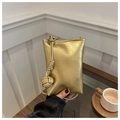 Detail einer goldenen Handy-Umhängetasche mit dekorativem gewebtem Seilknoten-Anhänger - Gold