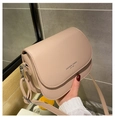 Detailed shot of a pale pink leather saddle bag featuring an embossed fashion logo - Khaki