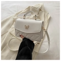 Detalle de bolso blanco acolchado con emblema de mariposa dorada y asa superior - Blanco