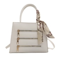 White trapezoid handbag with gold zippers and printed silk scarf wrapped around handle - White