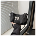 Detail of black pleated handbag featuring a silver bow metal buckle and knotted strap - Black