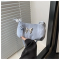 Detailed view of light blue marble textured handbag featuring a silver metal bow buckle - Blue