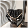 Detalle de bolso de mano negro plisado con una elegante cadena de perlas decorativas - Negro