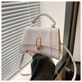 Macro detail of white crocodile-embossed leather handbag with elegant gold U-lock hardware - White