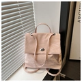 Detail of light pink backpack with pleated texture and silver twist lock on window sill - Pink