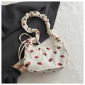 Dettaglio della stampa a fragola su borsa di velluto bianco con tracolla arricciata - Bianco