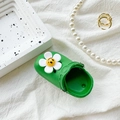 Green mini clog phone socket with a smiling daisy charm on white fabric - Dark Green