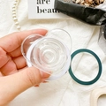 Detailed view of a transparent heart-shaped phone grip with an extra green adhesive ring - Magnetic Grip - Transparent Heart