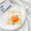 Macro view of mango bread scented squeeze toy in clear packaging on a white porcelain plate - Yellow (Mango Snack Bag)