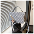 Detail of blue geometric plaid leather texture and gold metal bar on crossbody bag - Blue