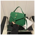 Dettaglio della borsa a tracolla in ecopelle verde con manico e fibbia dorata decorativa - Verde