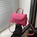 Fuchsia crossbody handtas met handvat en reliëf tekst op een strakke witte achtergrond - rozenroze