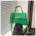 Detail of green croc-effect mini bag featuring golden twist lock and PU leather texture - Green