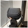 Detail of a black leather saddle bag with matte finish and gold metallic hooks - Black