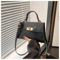 Detail of black crocodile texture leather bag with elegant golden metal twist lock closure - Black