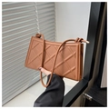 Detail of caramel brown quilted shoulder bag with decorative knotted rope strap and textures - Brown
