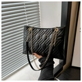 Detail of black quilted leather chain bag with elegant gold metal hardware and texture - Black
