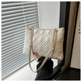 Close-up of white quilted tote with intricate rhombic stitching and gold chain strap - White