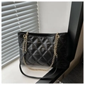 Detail der schwarzen Stepp-Tote Bag mit glänzendem Finish und goldenen Kettenriemen - Schwarz