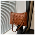 Close-up of brown quilted faux leather bag with gold chain strap and diamond stitching - Brown