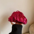 Metallic hot pink pleated cloud clutch bag with thin shoulder strap in hand - Rose Pink