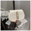 Dettaglio borsa a sella bianca con goffratura geometrica e chiusura in oro a mano - Bianco