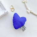 Dettaglio macro del supporto per telefono a cuore in peluche blu cobalto con etichetta - Blu