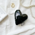 Detail of glossy black heart-shaped leather phone stand with fabric label and pearls - Black