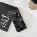 Detail of Samsung Z Flip case with 3D teddy bear charm and black beaded handle strap - Black / Samsung ZFlip3