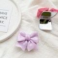 Detail view of pink and purple 3D bow-shaped folding mirrors with double-sided reflection - Purple